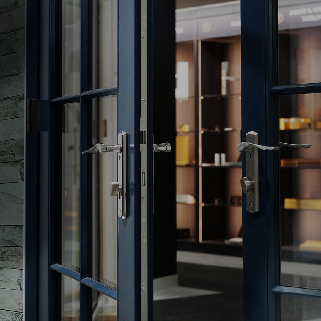 Blue patio double doors with stainless steel lever handles and thumb turn on a house