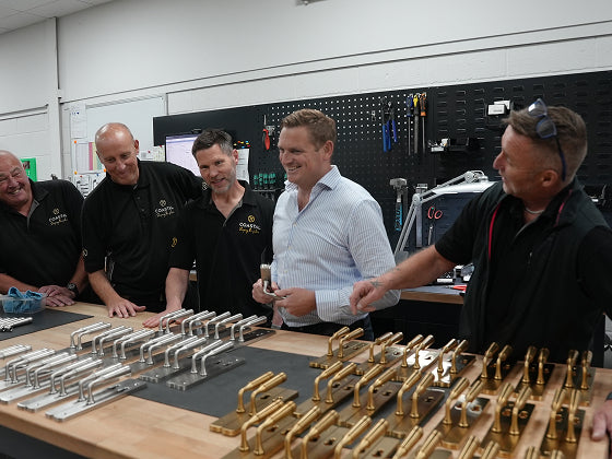 Assembly team with Coastal Group's Managing Director Loren Jenner in a workshop setting with Opera lever door handles